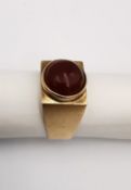 A 9ct yellow gold and carnelian cabochon dress ring. Set to centre with a round carnelian cabochon