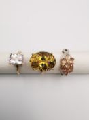 Three 20th century 9 carat gold gem-set rings with certificates. An Imperial topaz dress ring, a