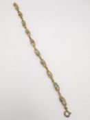A 9ct yellow gold rope twist turquoise brad cage bracelet. Comprised of ten articulated sections,