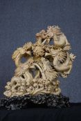 A soapstone figure of five entwined dragons on a hardwood plinth. Well carved and detailed with