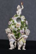 Vase supported by four cherubs and floral decoration. Probably nineteenth century. H.32 W.28 D.28