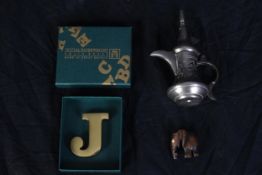 A solid brass paperweight in the shape of a 'J' and two others. A miniature hardwood elephant and