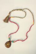 A Mughal style inlaid gem-set ruby drop pendant. The drop inlaid with a yellow metal floral and