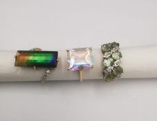 Three 20th century 9 carat gold gem-set rings. An ammolite triplet ring, a mystic topaz solitaire