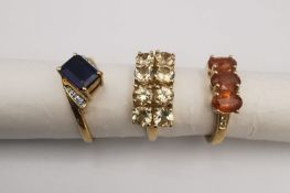 Three 20th century 9 carat gold gem-set rings, a sapphire and diamond twist flanked solitaire