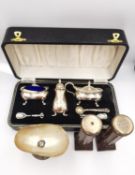 A cased silver cruet set (spoons not matching), a pair of carved silver topped column design salt