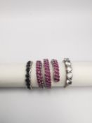 Three gems set silver rings, a ruby set silver coil ring, a blue five stone ring and a Bohemian