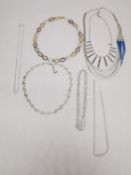 A collection of seven chains and necklaces, including an opal, turquoise and coral necklace, a tri