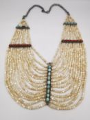 A 19th century Arabic mother of pearl bead multi strand collar necklace with coral and turquoise set
