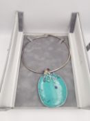 A boxed statement silver and multi gemstone turquoise pendant on silver snake chain. The top of