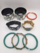 A collection of contemporary gemstone and shell bangles, a pair of inlaid mother of pearl and