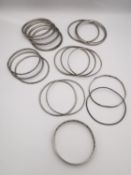 A collection of seventeen silver bangles, including a set of four textured thin bangles by Wai Kee