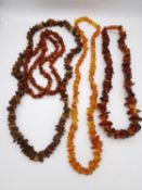 Four amber pebble and chips necklaces, one of pale honey colour. One fastens with a screw barrel