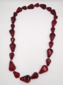 A knotted Cherry amber drop shape bead necklace. L.66cm