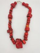 A Chinese large statement red branch coral bead necklace, comprising of large and small beads.