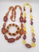 A collection of amber jewellery, including a long large amber bead necklace, an elasticated three