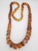 A long knotted amber graduated cube bead necklace. The necklace comprises of fifty nine beads