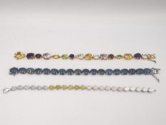 Three articulated silver and gold plated silver gem set bracelets, one set with opal triplets, one