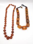 Two amber necklaces, a long graduated round bead necklace with barrel clasp and a large