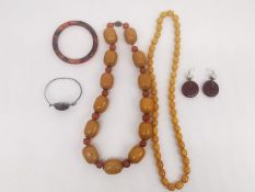 A collection of faux amber resin jewellery, including a Chinese early plastic and carnelian bead