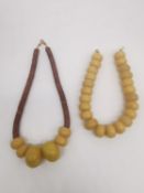 Two early 20th century East African large resin bead necklaces, one with plastic disc necklace. L.