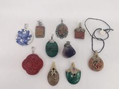 Ten gem set pendants, including a carved Chinese resin pendant, a malachite and silver pendant and a