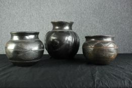 Three earthenware pots with intricate carved decorations. Early twentieth century but maybe older.