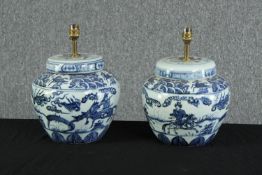 A pair of twentieth century blue and white ginger jars converted to lamps. Decorated with warriors