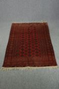Rug, Bokhara with repeating gul motifs on a burgundy field. L.172 W.123cm.