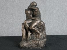 After Auguste Rodin. The Kiss. Bronzed moulded figure group. H.27 W.15 D.15 cm.