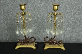A pair of candleholders. Bronze dragons supporting gilt metal trunks and decorated with hanging
