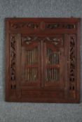 A carved Indian hardwood prison door mirror. H.90 W.80cm.