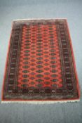 Carpet, Bokhara with repeating gul motifs on a burgundy field. L.187 W.131cm.
