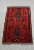 Rug, Shirvan with geometric borders on a burgundy ground. L.120 W.79cm.