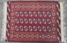 Rug, Bokhara, repeating gul motifs on a burgundy field. H.150 W.107