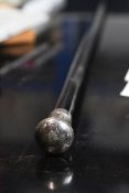 A ebony swagger stick with a silver plated pummel and engraved monogram.