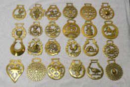 A collection of twenty four early 20th century horse brasses of various designs. x24.