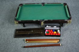 A table top pool table with cues and balls. H.19 W.92 D.51cm.