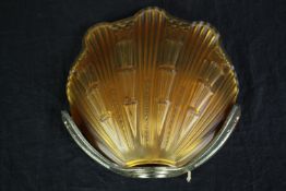 An Art Deco scallop shaped wall light. Coloured orange glass with a metal mount. H.26 W.25 cm.