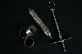 A tribal metal sugar hammer from the Tuareg people along with three silver napkin rings and a