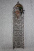 A large lattice iron screen. With feathers and a copper heart shaped decoration. Twentieth