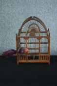 A decorative wooden birdcage with metal bars and a feathered bird. H.42 W.31 D.21 cm.