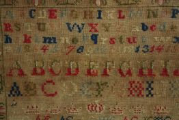 A framed sampler. Embroidered alphabet. Framed and glazed. H.40 W.42 cm.