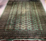 Carpet, a large Bokhara on a jade field within multiple stylised geometric borders. L.370 W.290cm.