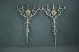 A pair of iron full height wall mounted candelabras. Each with five branches of lights. Painted