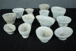 A collection of thirteen early 20th century stoneware and creamware jelly moulds of various designs.