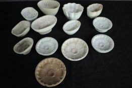 A collection of thirteen early 20th century stoneware and creamware jelly moulds of various designs.