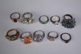 A collection of ten silver gem-set rings of various designs. Set with blue topaz, amethyst and ruby.