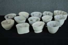 A collection of thirteen early 20th century stoneware and creamware jelly moulds of various designs.
