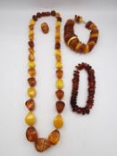 A collection of amber jewellery, including a long Baltic and butterscotch amber bead necklace with
